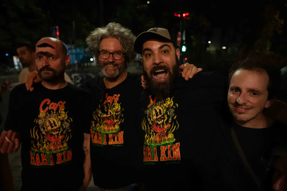 Quatre hommes souriants avec des t-shirts colorés